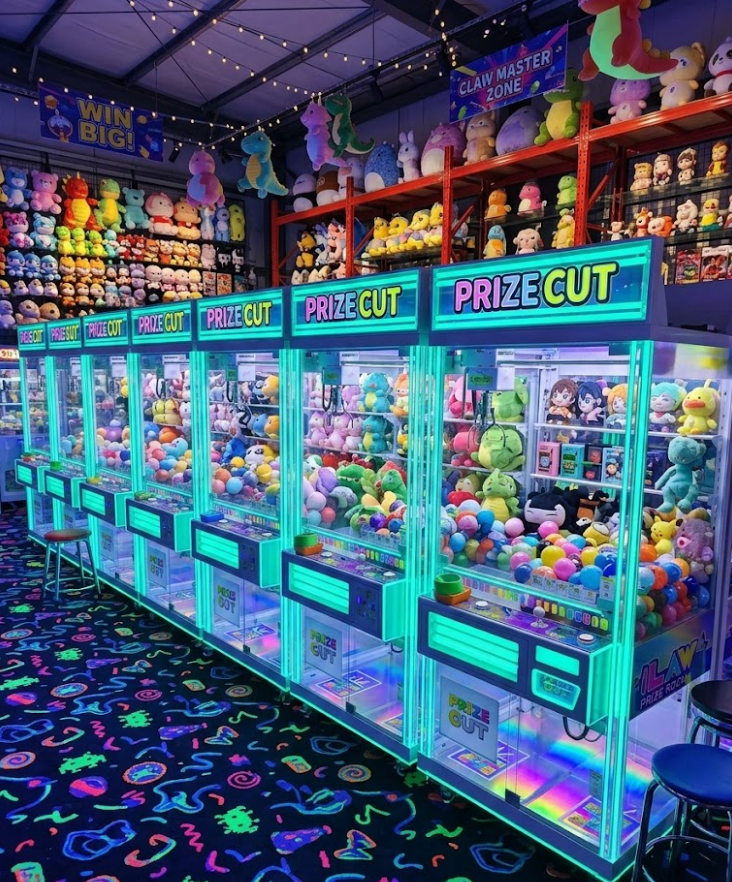 Neon arcade room with rows of glowing claw machines